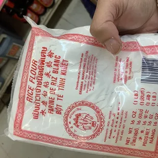 a hand holding a bag of rice