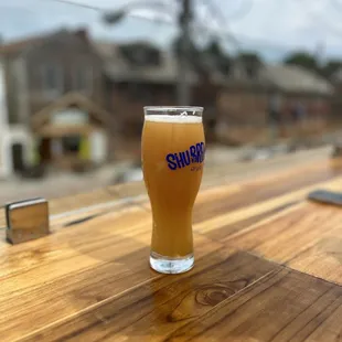 a glass of beer on a wooden table