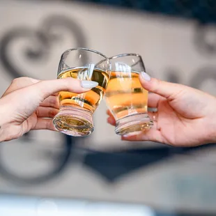 two people clinking glasses of beer