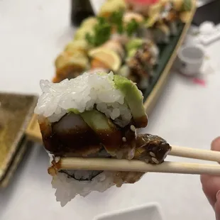 a person holding chopsticks with sushi on it