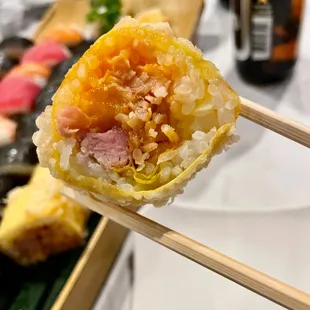 a close up of a sushi with chopsticks