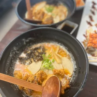 two bowls of ramen and a wooden spoon