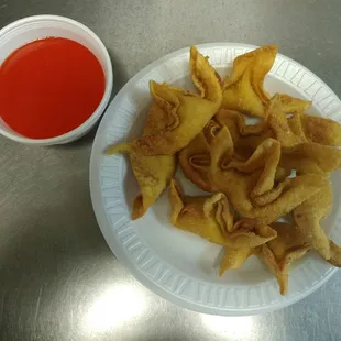a plate of fried dumplings and a bowl of ketchup