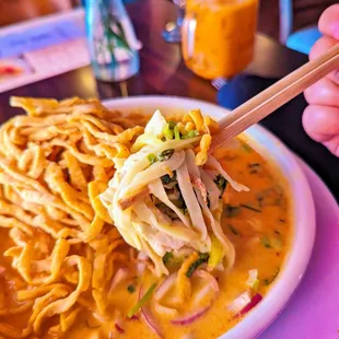 a bowl of noodles with chopsticks