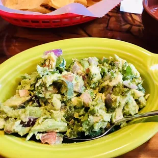 a bowl of guacamole and tortillas