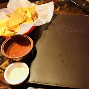 a tray of chips and salsa on a table