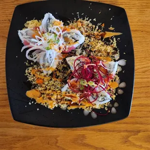 a black plate of food on a wooden table