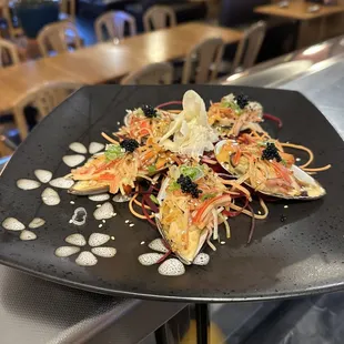 a black plate with a salad on it