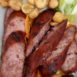 Thai Esan Sausage - Fried pork-rice Isaan fermented sausage served with lettuce, ginger, and peanuts