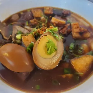 a bowl of soup with a boiled egg