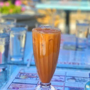 a glass of iced coffee on a table