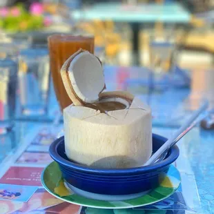 a coconut drink and a spoon on a plate