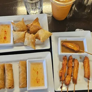Appetizers: Left to right: fried dumplings, top-crab ragoons, bottom-egg rolls, chicken satays on a stick, &amp; spring rolls