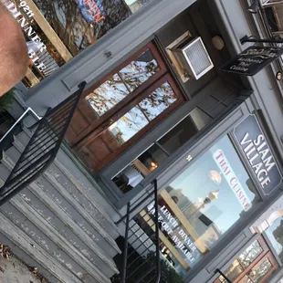 a man sitting on a bench in front of a restaurant