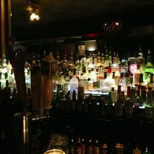 a dimly lit bar filled with liquor bottles