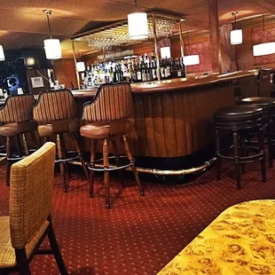 a bar with stools and tables