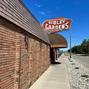 a brick building with a sign for sibley gardens