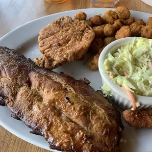 ows a plate of ribs, coleslaw and fried chicken