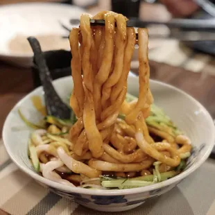 a bowl of noodles with chopsticks