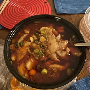 a person holding a bowl of soup