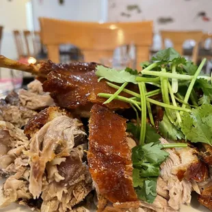 a plate of meat with greens on top