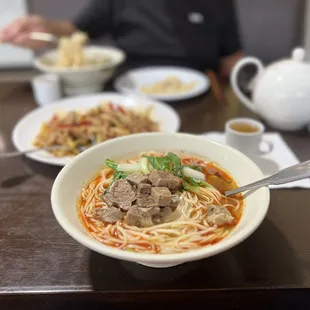 a bowl of noodles with meat and vegetables