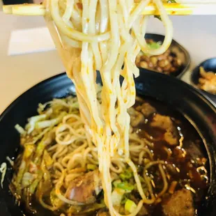 a bowl of noodles with chopsticks