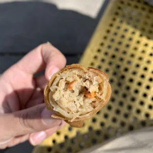 a person's hand holding a pastry