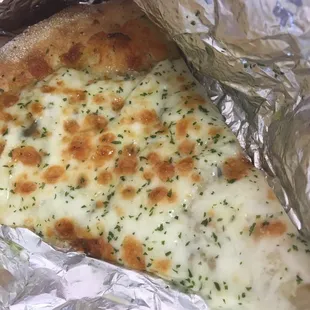 a slice of cheese pizza wrapped in foil