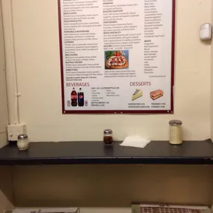 One of the walls, featuring part of the menu and strategically placed hot pepper flakes and Parmeasean.