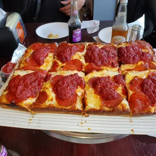 a square pizza with pepperoni on it