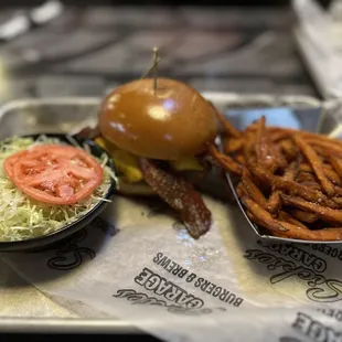 Lettuce and tomato on the side with a plain bacon cheeseburger and sweet potato fries