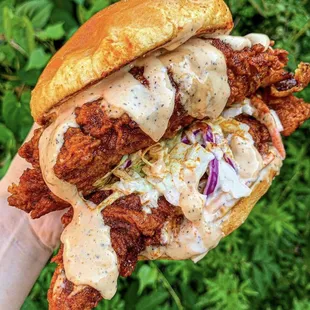 a hand holding a fried chicken sandwich