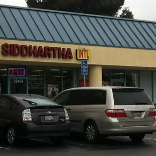 two cars parked in front of a store