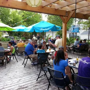 people sitting at tables under umbrellas