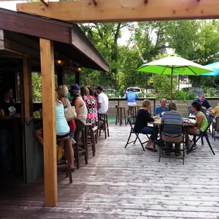a group of people sitting at tables under umbrellas