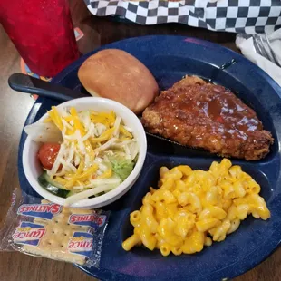 Lunch plate with country fried pork chop, salad, macaroni and cheese, side salad with Italian dressing, and dinner roll