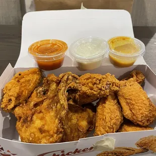 a box of fried chicken with dipping sauces