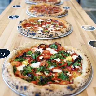 three pizzas on a wooden table