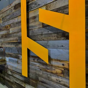 a wooden wall with a yellow logo