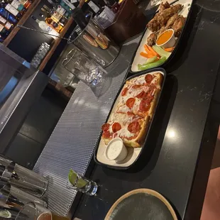 two plates of pizza on a bar
