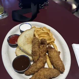 a plate of fried chicken, french fries, and ketchup