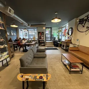 a coffeehouse with couches, tables, and bicycles on the wall