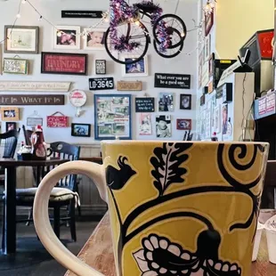 a yellow coffee cup with a floral design