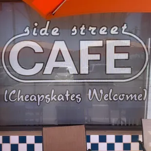 a table and chairs in front of a sign