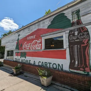 a coca cola sign painted on the side of a building