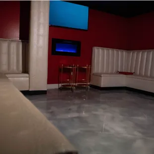 a red room with white booths and a tv