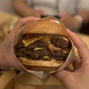  person holding a large hamburger