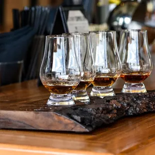 four glasses of whiskey on a bar