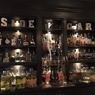 the back of a bar filled with liquor